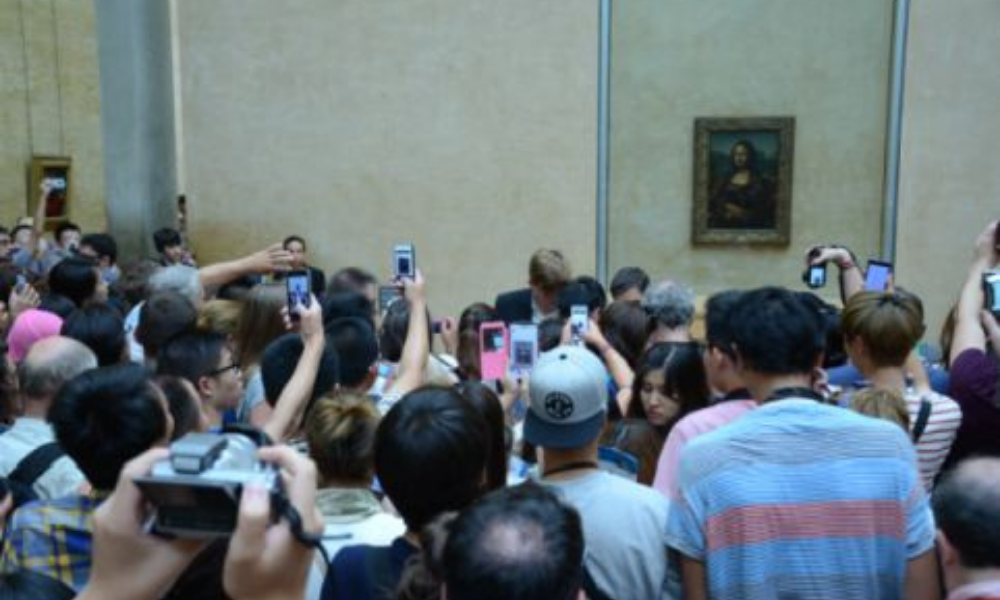 Group of tourists crowded in front of the Mona Lisa painting