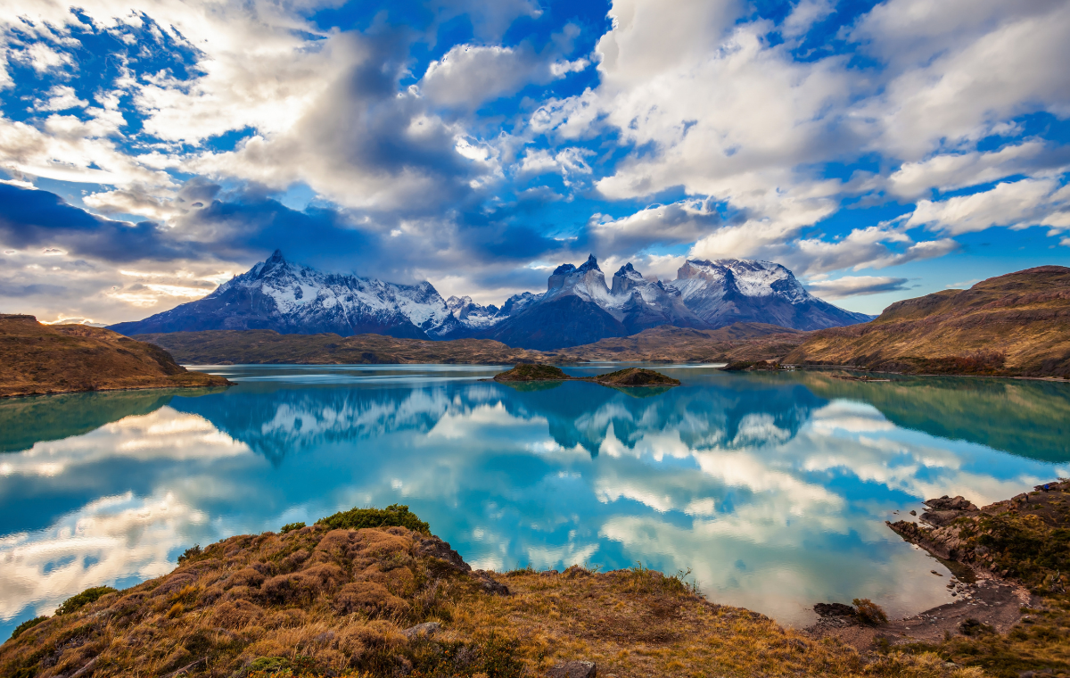 Reflective lake with snow-capped mountain range in the background