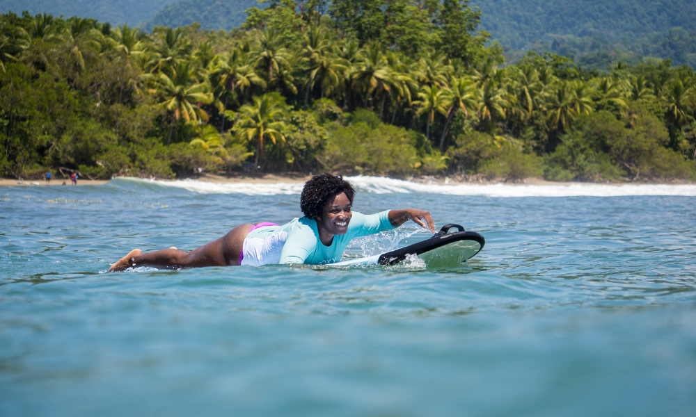 woman surfing and smiling in the ocean