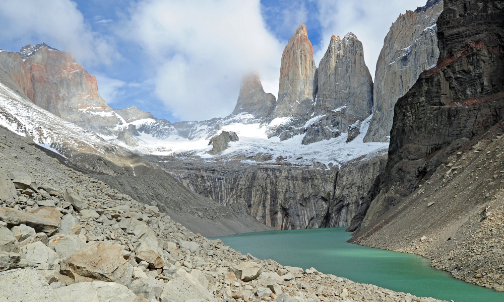 Base of the Towers Trail in Torres del Paine National Park, jagged mountain peaks with green pool of water in the foreground