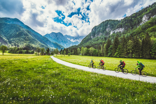 cyclists riding along flat mountain road ins lovenia